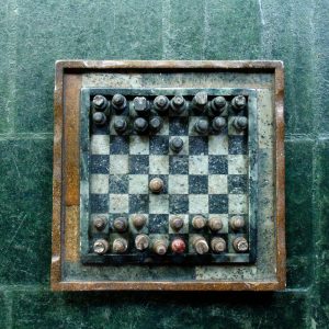 Top view of a vintage stone chessboard showing a strategic game position.