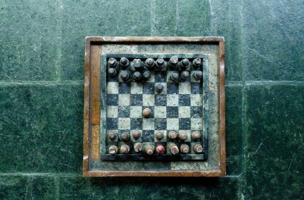 Top view of a vintage stone chessboard showing a strategic game position.